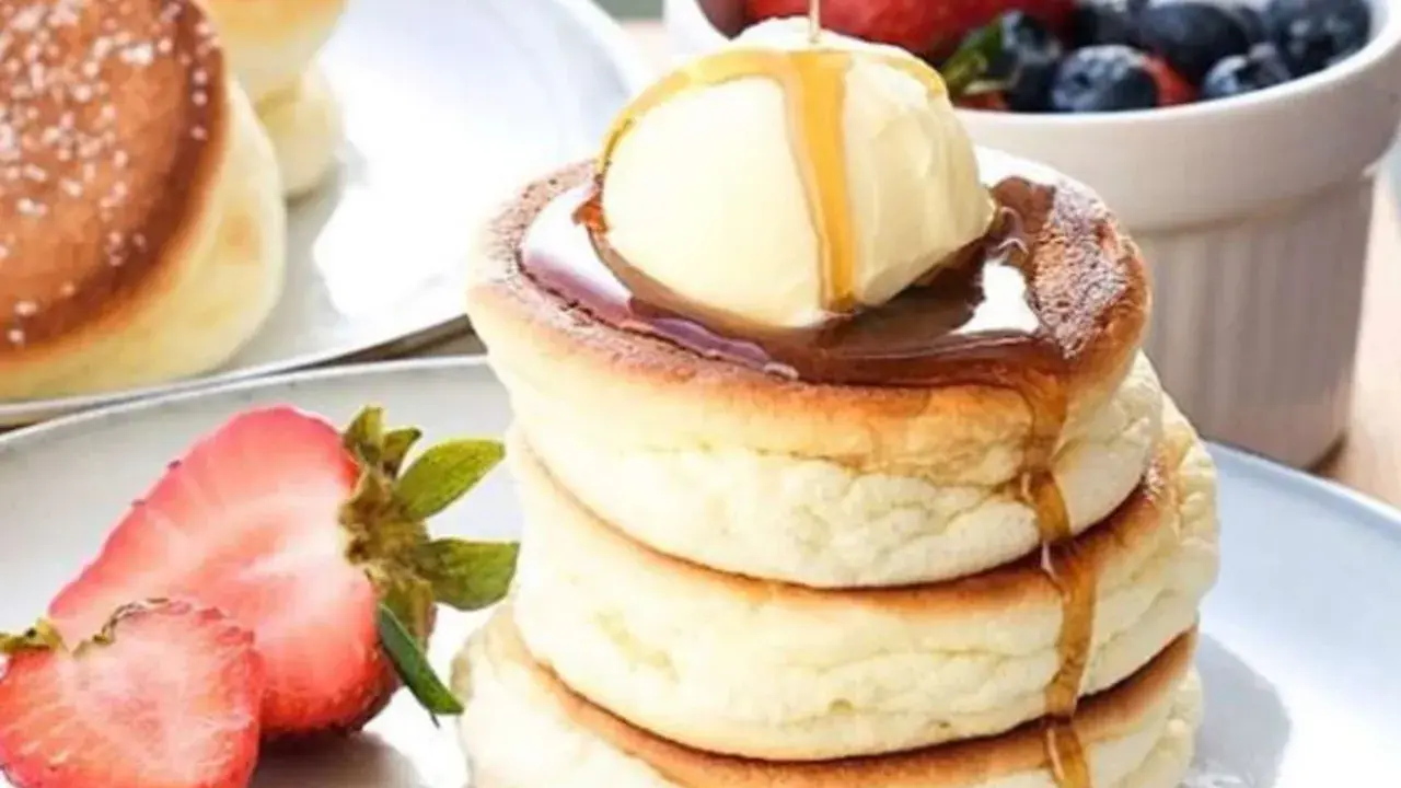 Fluffige japanische Pancakes mit einer Kugel Eis, Sirup und frischen Beeren. Ein Traum zum Frühstück!