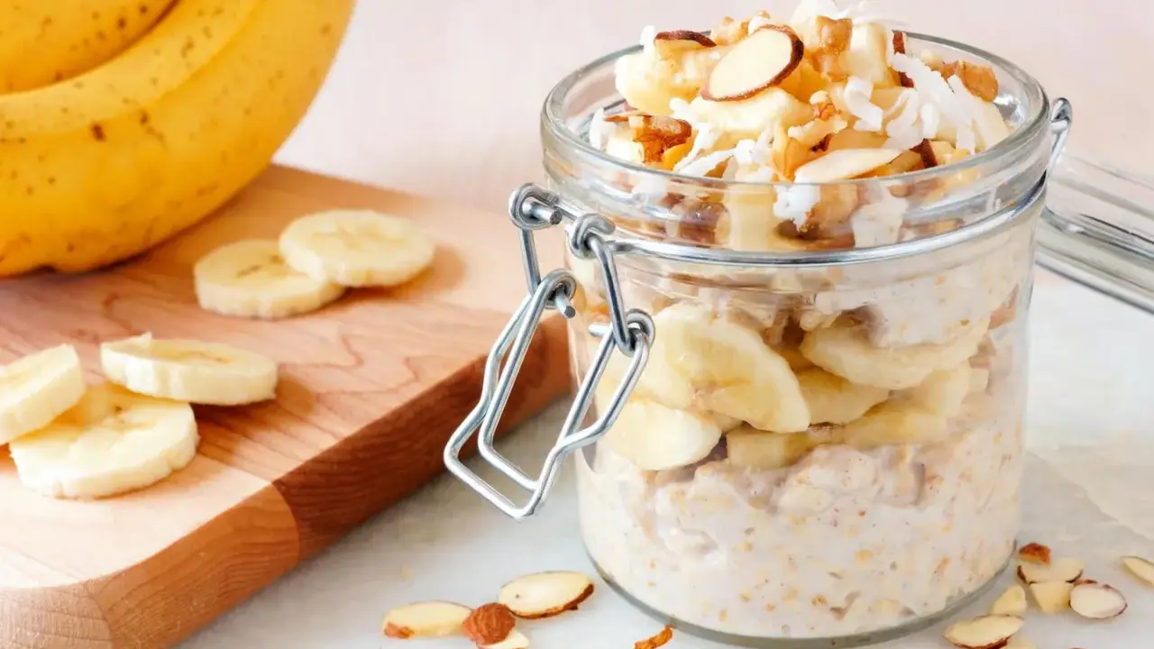 Gesunder Porridge mit Banane, Nüssen und Kokosraspeln im Glas. Perfekt für einen energiegeladenen Start in den Tag.