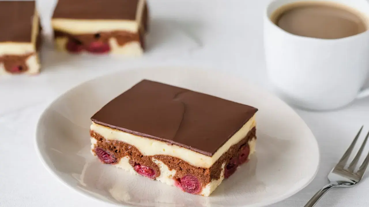 Schokoladenkuchen mit Kirschen und Vanillecreme, überzogen mit dunkler Schokolade. Ein köstliches Financier Rezept für Genießer.