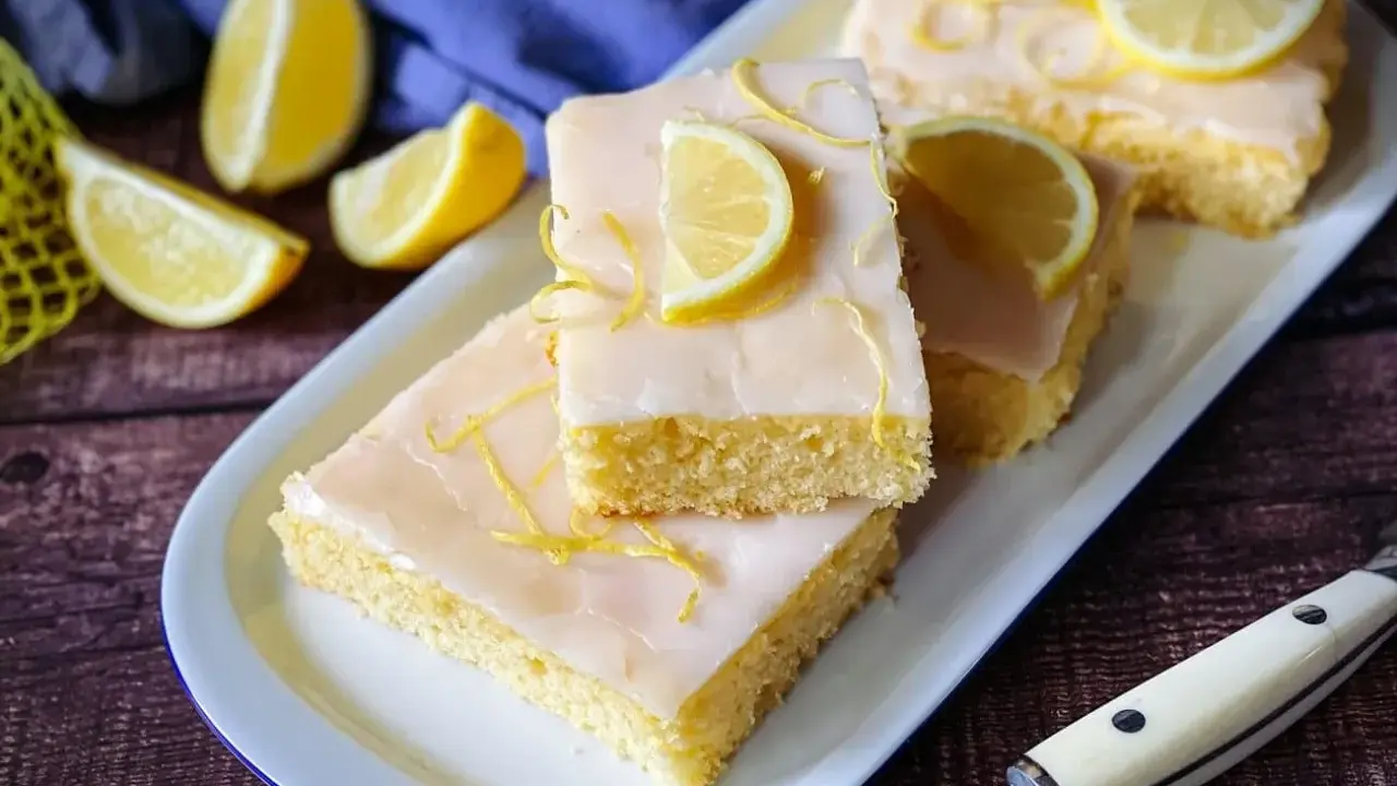 Fluffiger saftiger Zitronenkuchen mit Zuckerguss und Zitronenscheiben. Ein Genuss für jeden Kaffeetisch.