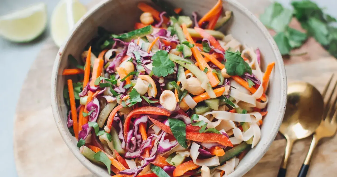 Bunter Reisnudelsalat mit Karotten, Rotkohl, Gurke und Erdnüssen. Ein frisches Rezept für heiße Tage.