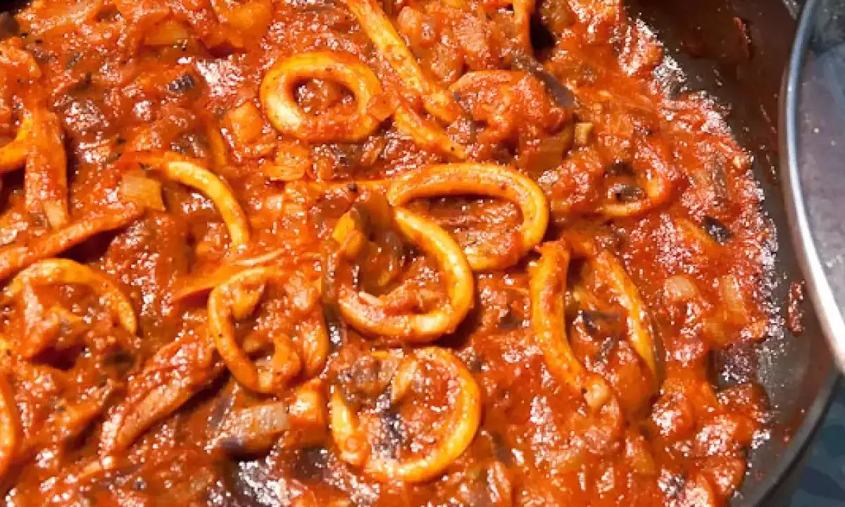 Sepia-farbene Tintenfischringe in einer würzigen Tomatensauce, perfekt für ein mediterranes sepia rezept.
