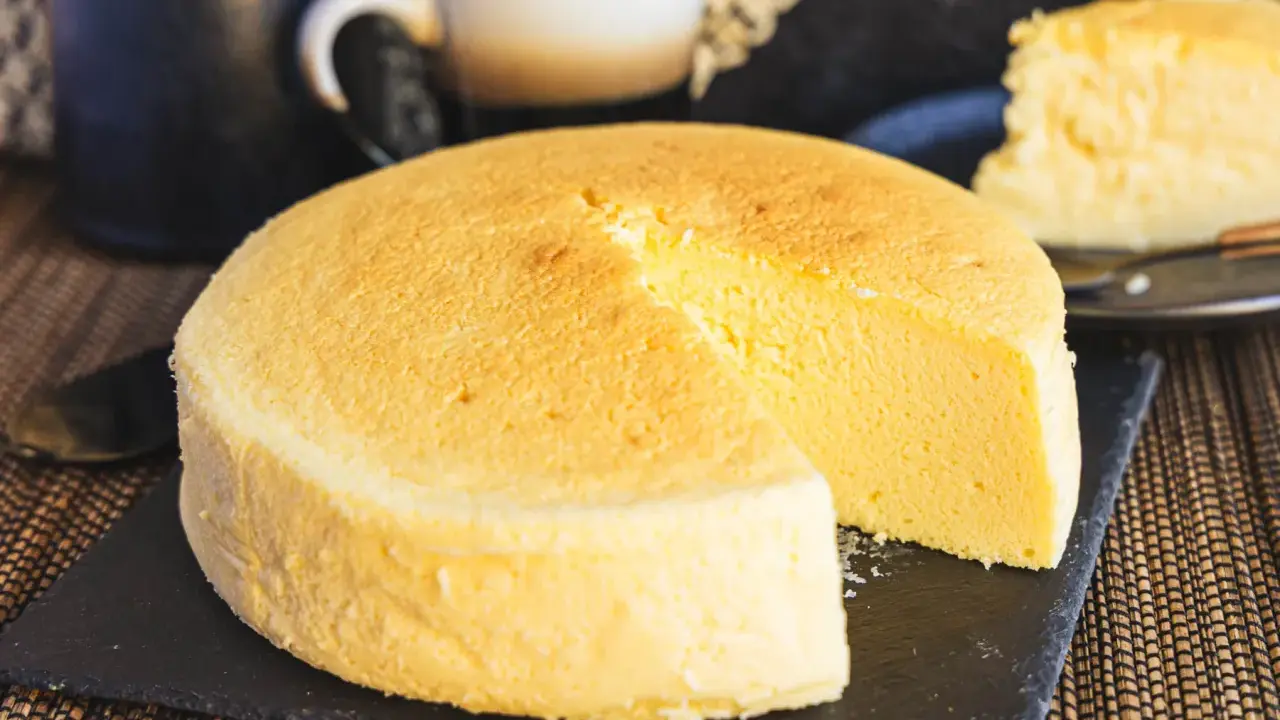 Fluffiger japanischer Käsekuchen, perfekt für Ihr nächstes japanisches Cheesecake-Rezept. Ein Stück ist bereits angeschnitten.
