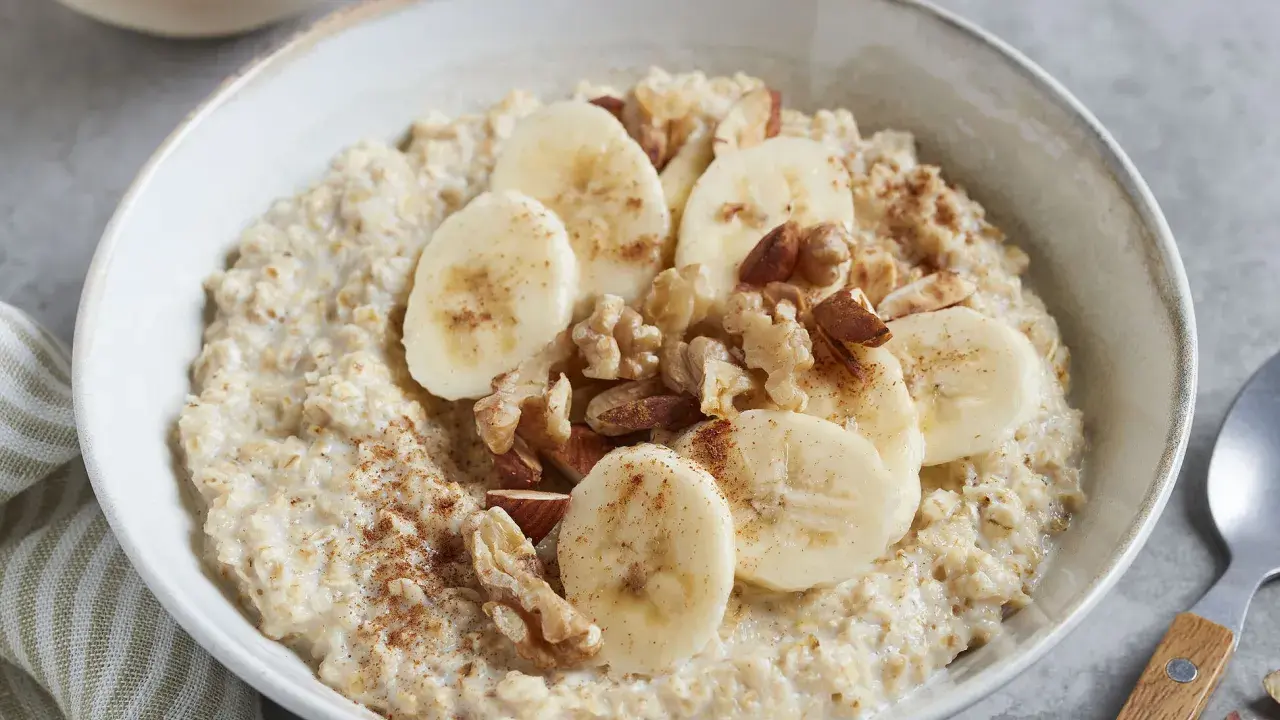 Cremiger Porridge mit Bananenscheiben, Nüssen und Zimt – ein leckeres Porridge Rezept mit Banane für einen guten Start in den Tag.