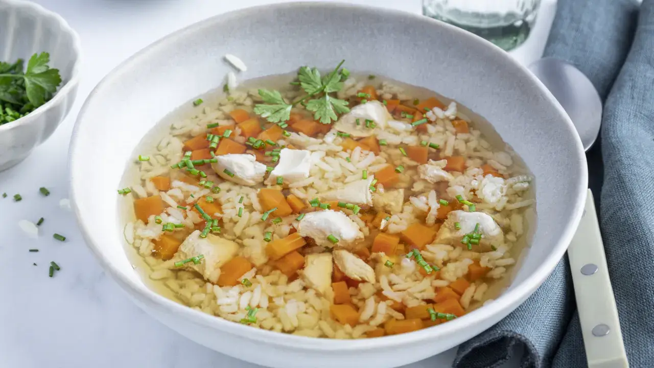 Eine wärmende Reissuppe mit Huhn, Karottenwürfeln und frischen Kräutern, perfekt für kalte Tage.