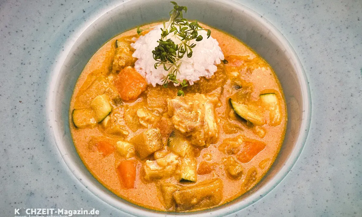 Ein cremiger Lachs Curry mit Reis und Gemüse, garniert mit frischen Sprossen.