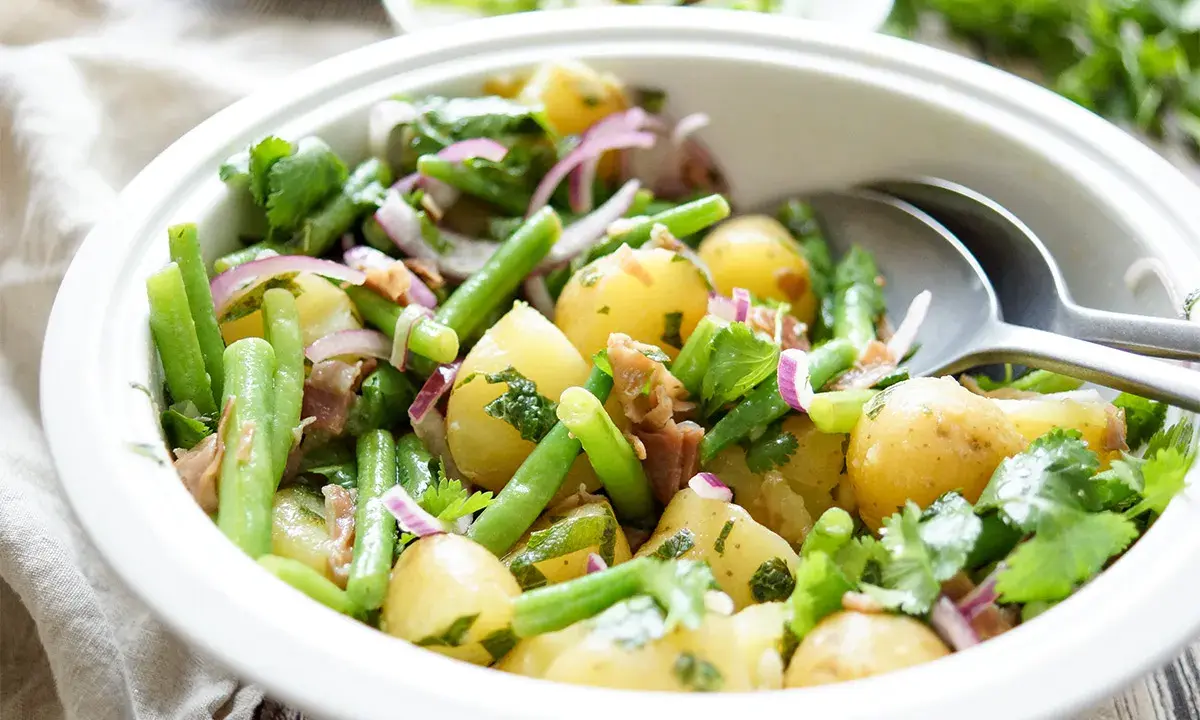 Kartoffelsalat mit grünen Bohnen, roten Zwiebeln und Kräutern. Perfekt als Beilage, was passt zu Bohnensalat?