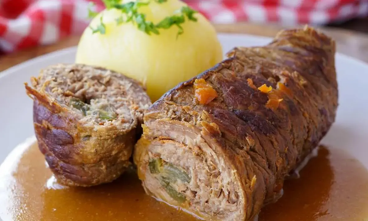 Zwei Rinderrouladen mit Kartoffelklößen und Soße. Was sind Rouladen? Gefüllte Fleischröllchen, ein Klassiker der deutschen Küche.