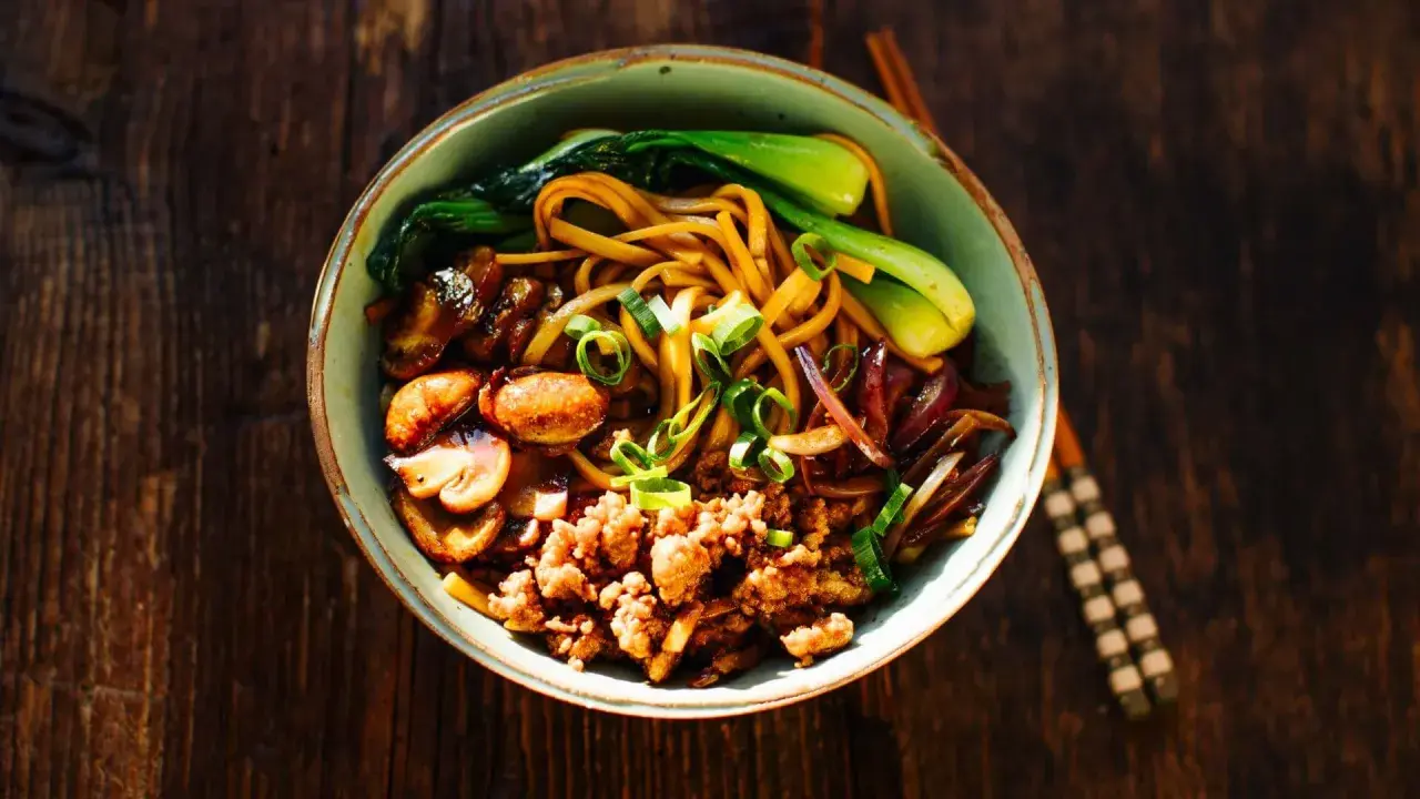 Schüssel mit Nudeln, Hackfleisch, Pilzen, Pak Choi und Zwiebeln – ein Beispiel für schnelle japanische Gerichte.