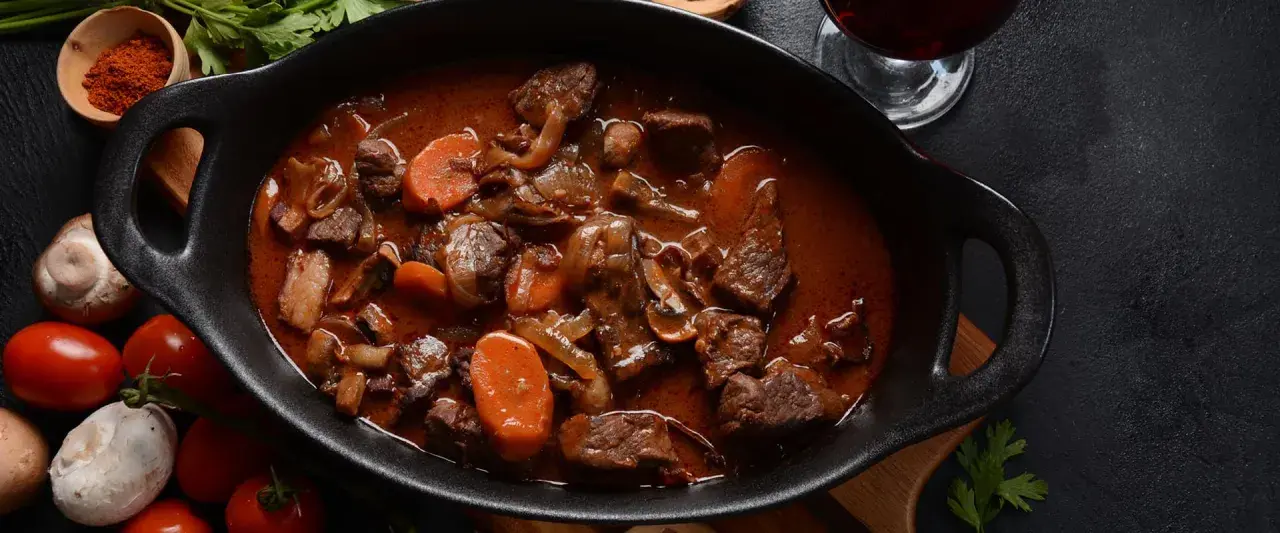 Herzhaftes Rehragout in dunkler Sauce mit Karotten und Pilzen. Welches Fleisch hier verwendet wurde, ist nicht ersichtlich, aber es sieht köstlich aus.