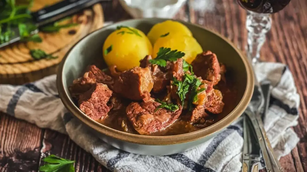 Herzhaftes Kalbsgulasch mit Kartoffeln, garniert mit Petersilie. Ein Festmahl, das man sich nicht entgehen lassen sollte – das beste Kalbsgulasch!