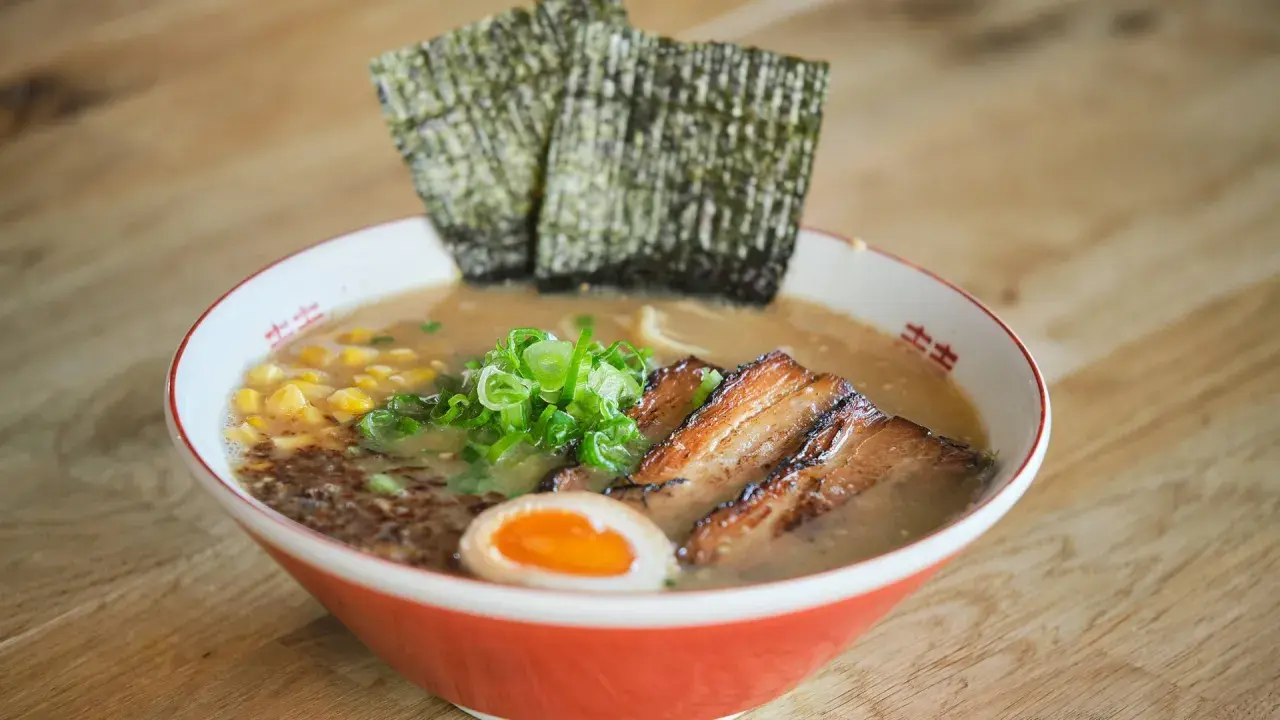 Herzhaftes Miso Ramen mit zartem Schweinebauch, Mais, Frühlingszwiebeln, Ei und Nori-Algen.