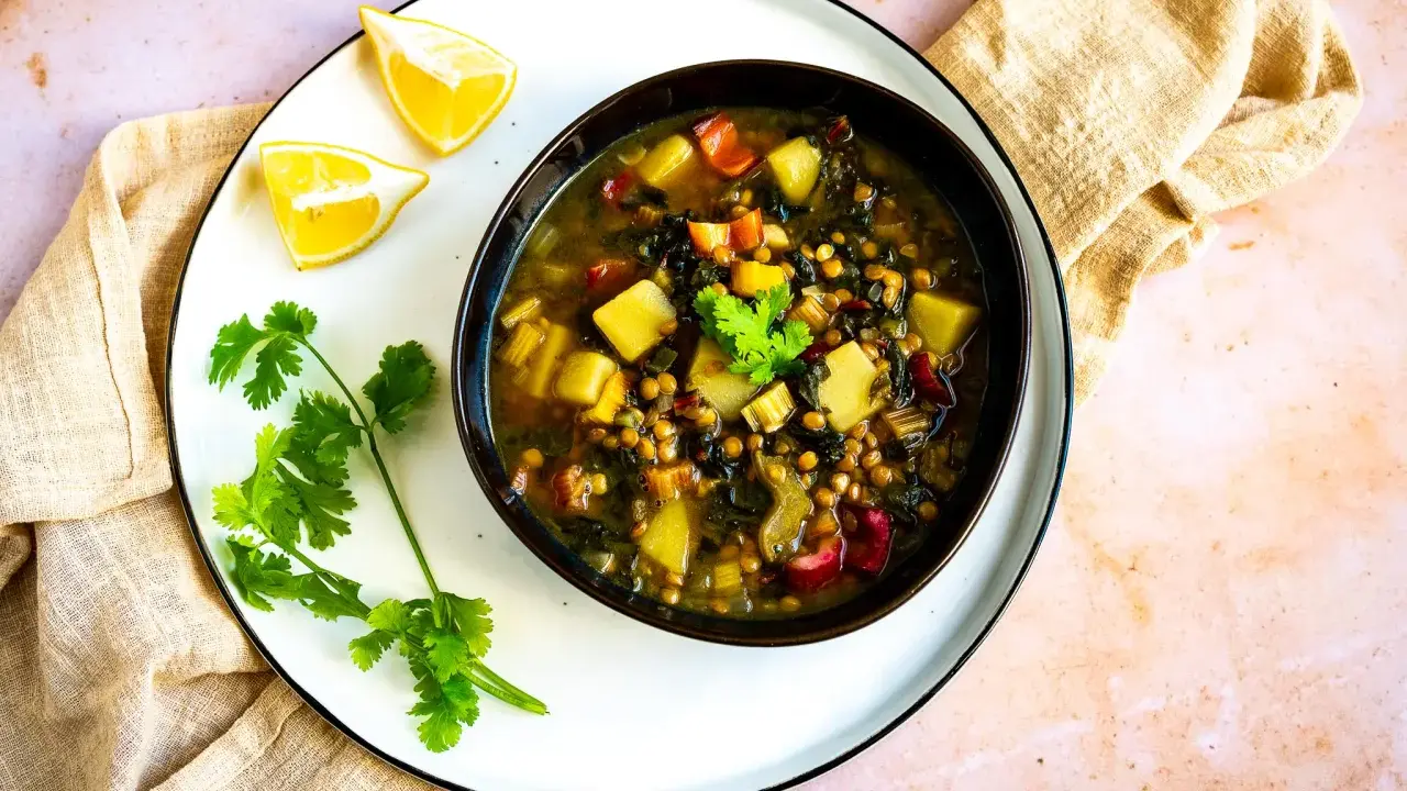 Herzhafte mangold suppe arabisch mit Linsen, Kartoffeln und Koriander. Serviert mit Zitronenspalten.