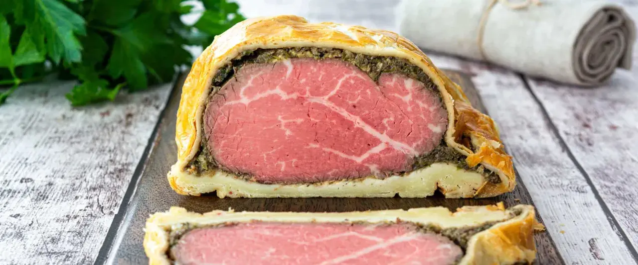 Ein perfekt zubereitetes Beef Wellington mit saftigem Rinderfilet, Pilzduxelles und Blätterteig.