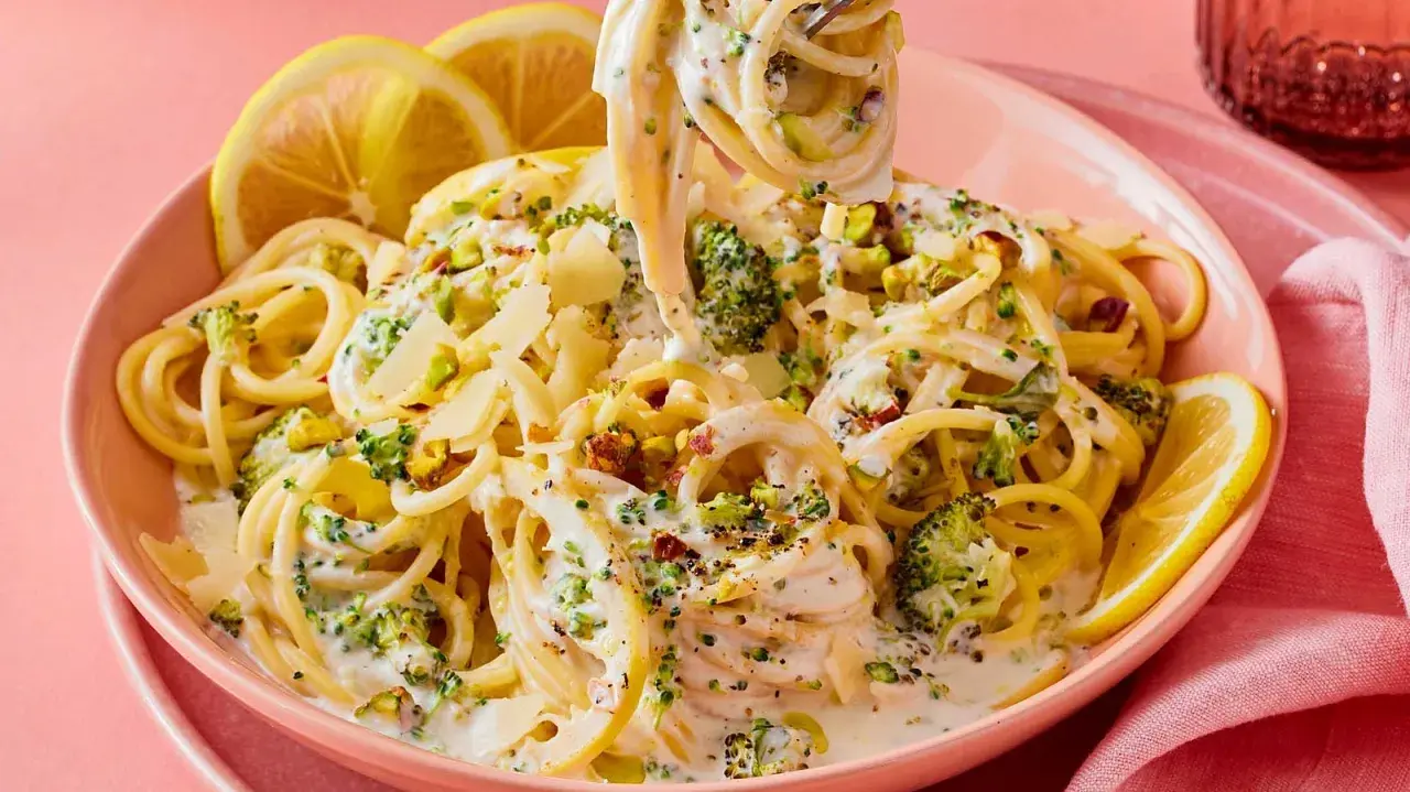 Cremige Pasta mit Brokkoli, garniert mit Pistazien und Zitronenspalten. Ein köstliches italienisches Gericht, das Lust auf mehr macht.