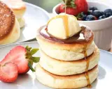 Fluffige japanische Pancakes mit einer Kugel Eis, Sirup und frischen Beeren. Ein Traum zum Frühstück!
