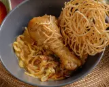 Khao Soi: Hühnerkeule in cremiger Kokosmilch-Currysauce mit weichen und knusprigen Nudeln.