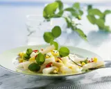 Ein frischer Spargel Mango Salat mit roten Paprikastückchen und grünen Blättern, garniert mit zarten Sprossen.
