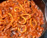 Sepia-farbene Tintenfischringe in einer würzigen Tomatensauce, perfekt für ein mediterranes sepia rezept.