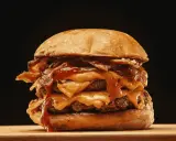 Ein saftiger Burger zubereiten: Doppelt Fleisch, geschmolzener Käse, knuspriger Bacon und eine köstliche Sauce.