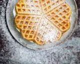 Herzförmige Waffeln mit Puderzucker bestreut, serviert auf einem Teller. Ein Genuss, der an Sommer und Kokosmilch erinnert.