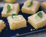 Saftige Kuchenstücke mit Zitronenguss, garniert mit Zitronenspalten und Minze. Ein Genuss, der nach dem besten zitronenkuchen der welt schmeckt.