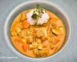 Ein cremiger Lachs Curry mit Reis und Gemüse, garniert mit frischen Sprossen.