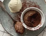 Ein warmer, flüssiger Kern im Moelleux au chocolat, serviert mit einer Kugel Vanilleeis und Kakaopulver.