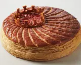 Goldbraune Galette des Rois mit einer Krone aus Blätterteig, die die traditionelle Epiphanie-Feier symbolisiert.
