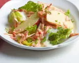 Erfrischender karotten apfel-salat mit joghurt und knackigem Salat, garniert mit Kresse.