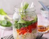 Eine köstliche pak choi suppe in einem Glas, geschichtet mit Nudeln, Gemüse und Fleisch.