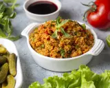 Frischer Bulgursalat mit Tomaten, Kräutern und Minze, serviert mit Gurken und Limette. Das beste bulgursalat rezept für einen leichten Genuss.