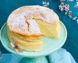 Ein luftiger, japanischer Kuchen, bestäubt mit Puderzucker, steht auf einem mintgrünen Tortenständer. Ein Schmetterling sitzt am Rand.