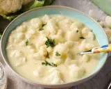 Cremige blumenkohlsuppe thermomix ohne kartoffeln, garniert mit Petersilie. Ein Löffel mit buntem Muster liegt in der Schüssel.
