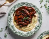 Herzhaftes Pilz-Bourguignon auf cremigem Kartoffelpüree, garniert mit frischen Kräutern. Ein Genuss für jeden Gaumen.