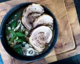 Schüssel mit Ramen-Nudeln, Brühe, Frühlingszwiebeln und drei Scheiben Chashu-Schweinebauch. Ein köstliches Chashu-Rezept!