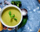 Grüne Detox-Suppe mit frischem Basilikum, dazu Baguettescheiben, Knoblauch und Brokkoli.