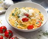 Cremiges One Pot Orzo mit Kirschtomaten, Spinat und Parmesan, garniert mit frischem Thymian.