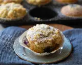 Saftige Blaubeermuffins mit Joghurt und Streuseln, bestäubt mit Puderzucker. Ein Genuss für jeden Kaffeetisch.