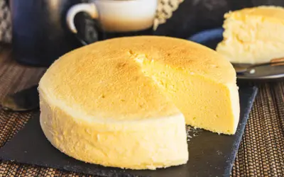 Fluffiger japanischer Käsekuchen, perfekt für Ihr nächstes japanisches Cheesecake-Rezept. Ein Stück ist bereits angeschnitten.