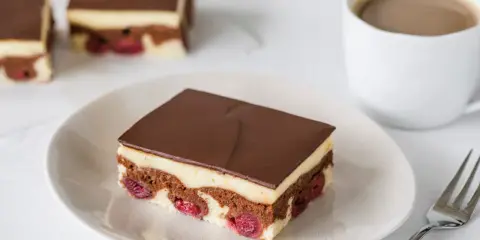 Schokoladenkuchen mit Kirschen und Vanillecreme, überzogen mit dunkler Schokolade. Ein köstliches Financier Rezept für Genießer.