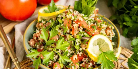 Frischer Tabbouleh Salat, ein authentisches Rezept, garniert mit Petersilie und Zitrone. Perfekt für ein leichtes Mittagessen.