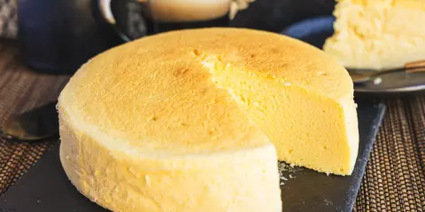 Fluffiger japanischer Käsekuchen, perfekt für Ihr nächstes japanisches Cheesecake-Rezept. Ein Stück ist bereits angeschnitten.