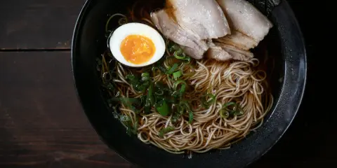Schüssel mit Nudeln, Fleisch, Ei und Frühlingszwiebeln. Ein authentisches Ramen Rezept Original.