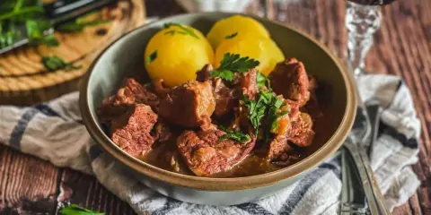 Herzhaftes Kalbsgulasch mit Kartoffeln, garniert mit Petersilie. Ein Festmahl, das man sich nicht entgehen lassen sollte – das beste Kalbsgulasch!
