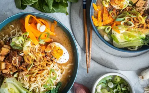 Zwei Schüsseln Miso Ramen mit Nudeln, Ei, Karotten, Pak Choi und Tofu. Ein leckeres miso ramen recipe.