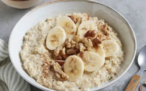 Cremiger Porridge mit Bananenscheiben, Nüssen und Zimt – ein leckeres Porridge Rezept mit Banane für einen guten Start in den Tag.