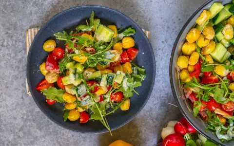 Knuspriger Gnocchi Salat aus dem Airfryer mit Tomaten, Gurken und Rucola, verfeinert mit einem cremigen Dressing.