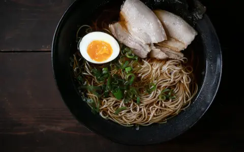 Schüssel mit Nudeln, Fleisch, Ei und Frühlingszwiebeln. Ein authentisches Ramen Rezept Original.