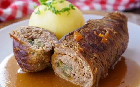 Zwei Rinderrouladen mit Kartoffelklößen und Soße. Was sind Rouladen? Gefüllte Fleischröllchen, ein Klassiker der deutschen Küche.